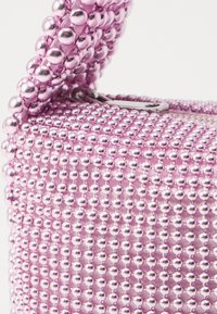 Beaded handbag in light pink with metallic beads. Features a structured shape and a top handle, showcasing a smooth, shiny texture.