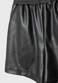 Shorts noirs en similicuir avec ceinture élastique et légers plis, texture lisse et finition mate.