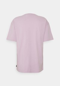 Ljuslila t-shirt med kort ärm, tillverkad av bomull, med rund hals och rak passform, som har en liten etikett på undersidan.