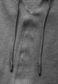 Pullover grigio con scollatura a V, caratterizzato da un tessuto testurizzato, cordini con punte in plastica e cuciture visibili lungo le cuciture.