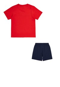 Camiseta de algodón roja con cuello redondo y mangas cortas, combinada con pantalones cortos de algodón azul oscuro que cuentan con una cinturilla elástica.