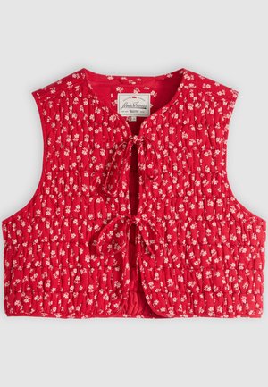 Κόκκινο αμάνικο γιλέκο με καπιτονέ σχέδιο, μικρό λευκό λουλουδένιο μοτίβο και δύο μπροστινές κλειδαριές με κορδόνια, με ετικέτα που δείχνει την επωνυμία Levi Strauss.