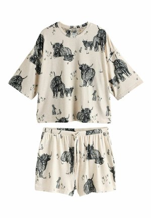 Beiges Freizeitoutfit mit kurzen Ärmeln und schwarzen Tierzeichnungen, darunter Kühe und Kaninchen. Shorts mit elastischem Bund und lockerem Schnitt.