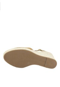 Sandalia cuña con parte superior texturizada en color beige, plataforma trenzada blanca y suela de goma con estrías para mayor agarre. Detalle de hebilla en tono dorado.