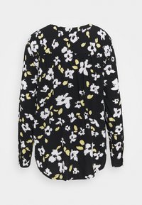 Blouse noire à manches longues avec imprimé floral blanc et jaune pâle, ourlet arrondi et détail froncé sous le empiècement au dos.
