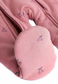 Ružičasti zip-up odjevni predmet od mekanog materijala, s uzorkom trešnje. Manšete imaju zaobljen oblik s suptilnim uzorcima trešnje.