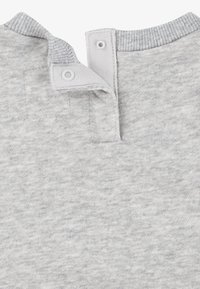 Colletto di camicia in cotone grigio con due bottoni a pressione, tessuto testurizzato e bordo a costine. Design semplice senza motivi o decorazioni.