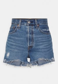 Shorts in denim blu medio con orlo sfrangiato, vita alta, cinque tasche e dettagli logorati sulla parte anteriore. Chiusura con bottone metallico.