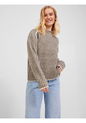 Bruine en crèmekleurige gestreepte sweater met een ribbelstructuur, ronde hals en lange mouwen, gecombineerd met lichtblauwe denim jeans.