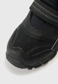 Mustad spordijalats, mis ühendab vastupidava kangaga sünteetilist materjali. Varustatud takjapaelaga ja kummist tallaga, millel on tekstuuriga muster.