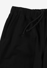 Czarne szorty wykonane z tkaniny syntetycznej, z elastycznym paskiem w talii i sznurkiem do regulacji. Posiadają kieszenie boczne i gładką fakturę.