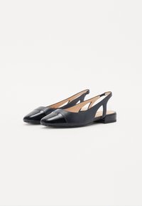 Chaussures noires à talon ouvert avec un bout pointu brillant, tige en cuir lisse, détail découpé sur le côté et un petit talon carré.