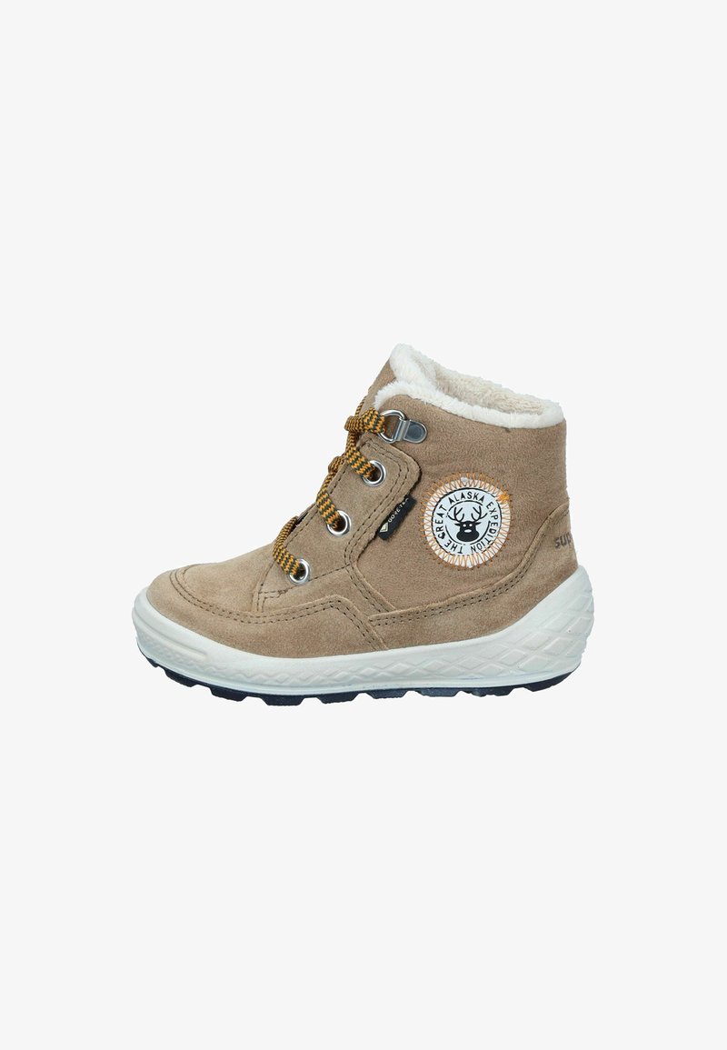 Beige Wildleder Winterstiefel für Kinder mit weißem Futter, gelben und schwarzen Schnürsenkeln sowie einem Patch "Great Alaska Expedition" an der Seite.