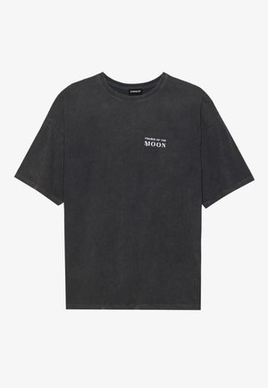 T-shirt in cotone nero con vestibilità ampia, con testo "FASI DELLA LUNA" in bianco sul lato sinistro del petto. Maniche corte, design a girocollo.
