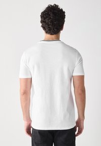 Weißes T-Shirt mit kurzen Ärmeln und Rundhalsausschnitt, mit einem schwarzen Akzent am Kragen. Glatte Textur, normale Passform, schlichtes Design.