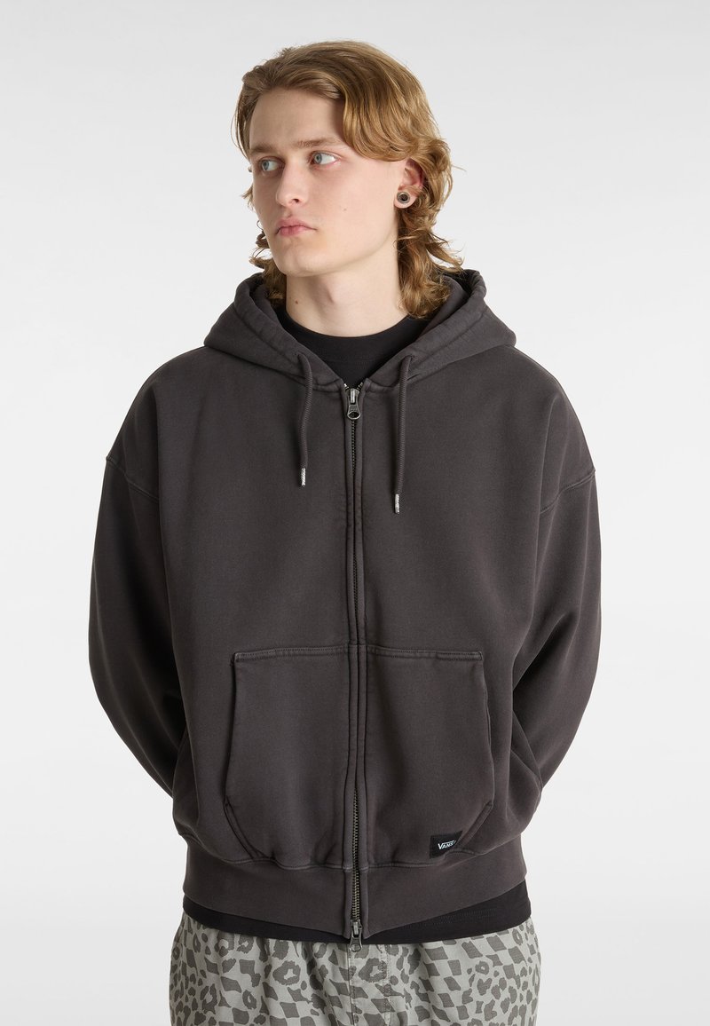 Graue Zip-Hoodie aus einem Baumwollmischgewebe. Verfügt über eine große Fronttasche, eine Kapuze mit Kordelzug und gerippte Bündchen. Lässige, lockere Passform.