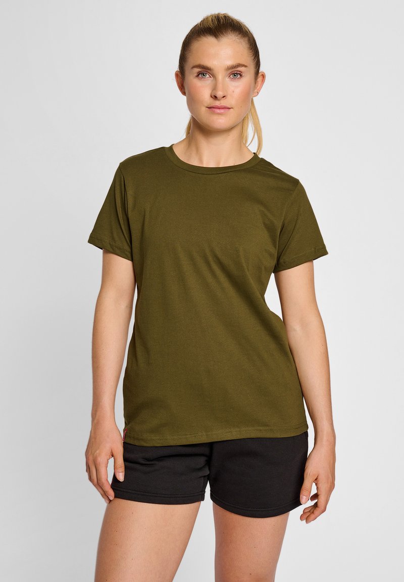 Oliven grøn bomulds t-shirt med rund hals, korte ærmer og en afslappet pasform. Sættes sammen med sorte shorts, der viser minimalt synlige syninger.