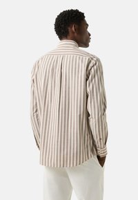 Langärmeliges Hemd mit vertikalen Streifen in Beige und Braun. Hergestellt aus leichtem Stoff mit geradem Saum und knöpfbaren Manschetten.