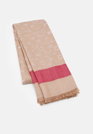 Lichtbruine opgevouwen sjaal met patroon van witte verspreide letters, een brede horizontale rode streep en franjesranden op een witte achtergrond.