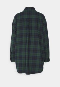 Grünes und marineblaues kariertes Flanellhemd mit einer Rückenpasse und Knopfmanschetten, das eine lockere Passform und eine weiche Textur bietet.