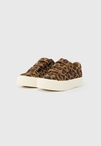 Låga sneakers med brunt och svart leopardmönster, två kardborreband och tjocka vita gummisulor på vit bakgrund.