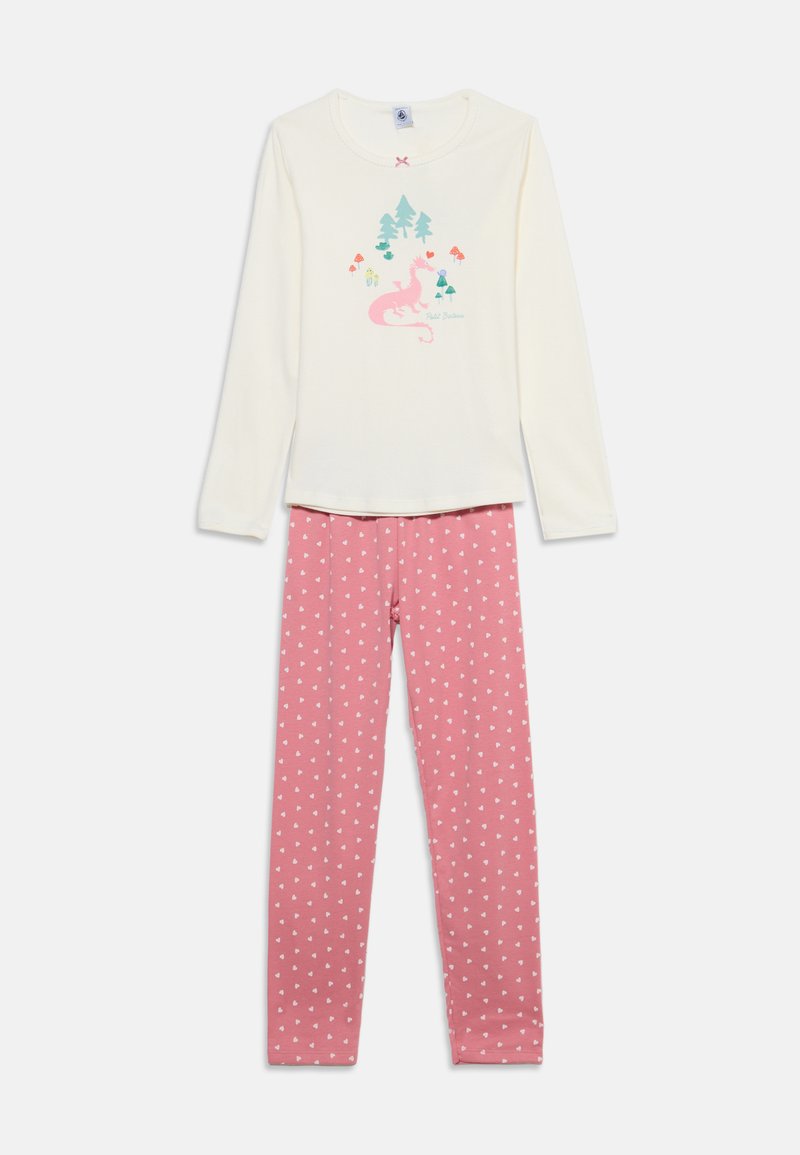 Haut crème à manches longues avec imprimé de dragon rose et d’arbres, associé à un legging rose avec petits motifs de cœurs blancs.