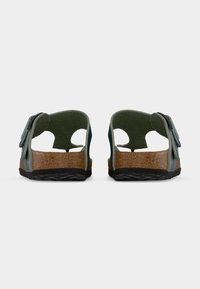 Ζευγάρι πράσινων σανδαλιών με ανοιχτή πλάτη, φτέρνες από φελλό και μαύρα ρυθμιζόμενα λουριά, φωτογραφημένα από πίσω σε λευκό φόντο.