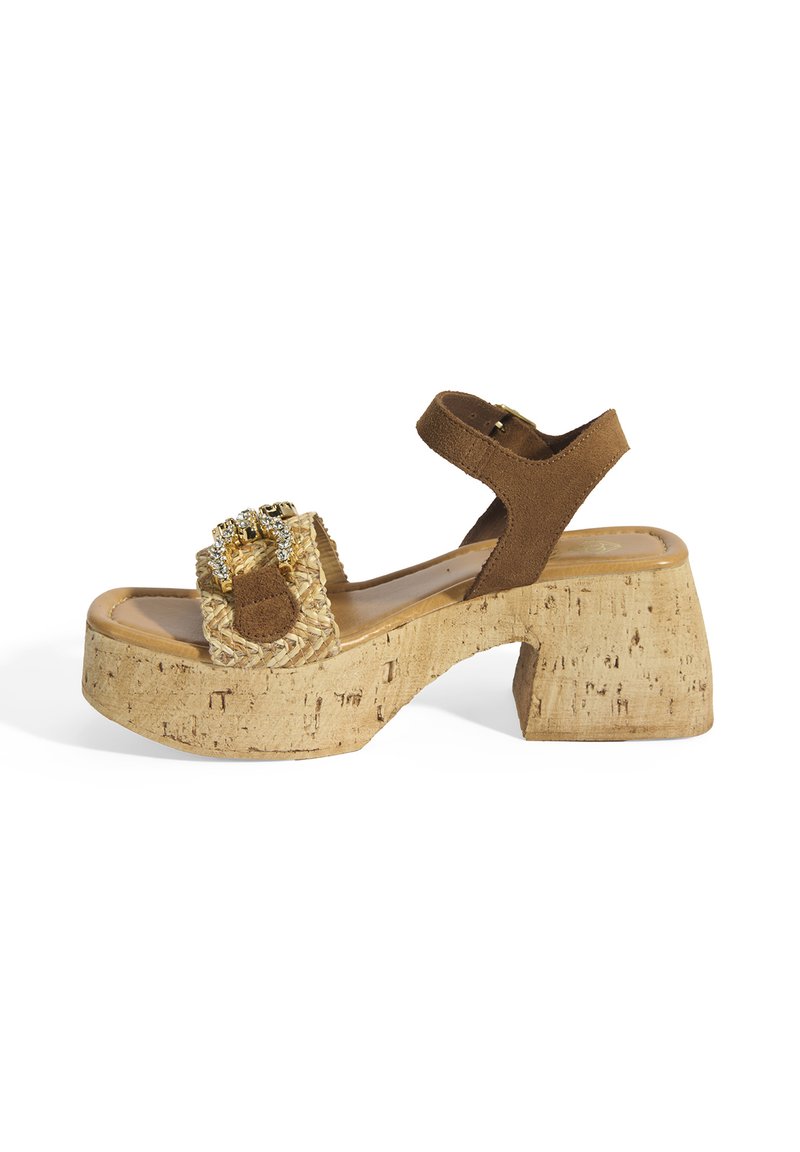 Braune Wildleder-Plattform-Sandalen mit Korkabsatz, ausgestattet mit gewobenem Strohdetail und dekorativen Beschlägen am vorderen Riemen. Verstellbarer Knöchelriemen.