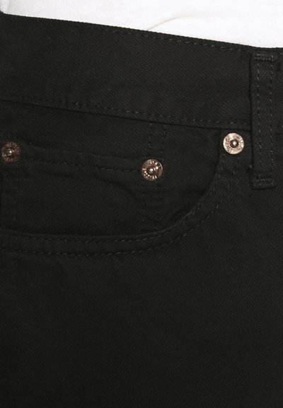 Black jeans featuring a subtle texture, five-pocket design, and copper-tone hardware with stitching details.