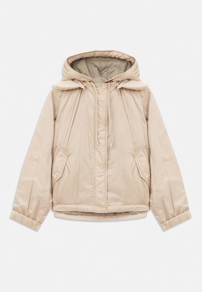 Veste rembourrée beige avec capuche, poignets élastiques et deux poches latérales. Elle présente une texture lisse et des détails à cordon au col.