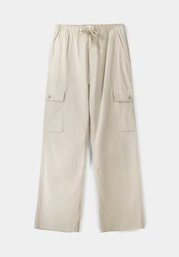 Beżowe spodnie cargo z elastyczną talią i sznurkiem, posiadające dwie boczne kieszenie oraz dwie kieszenie cargo na guziki. Materiał bawełniany.