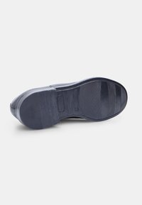 Semelle en caoutchouc navy avec texture antidérapante, présentant un bout arrondi et un talon moulé. Comprend un détail de logo circulaire sur la semelle intermédiaire.