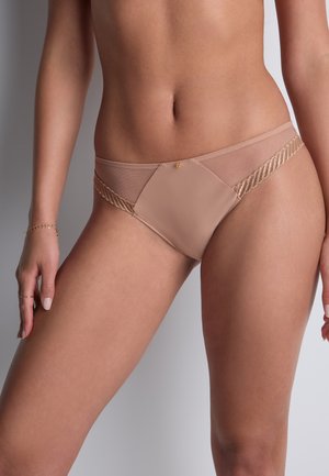 Sous-vêtements transparents beiges avec un motif géométrique, présentant un accent en dentelle texturée sur les côtés et un petit ornement doré à l'avant.