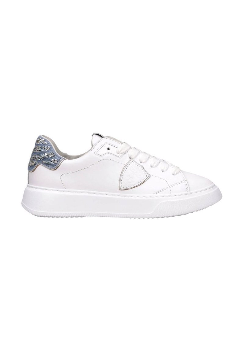 Las zapatillas de cuero blanco presentan un acabado suave, puntera redonda y suela plana. Los acentos de lentejuelas plateadas y azules en el talón completan el dise�ño.