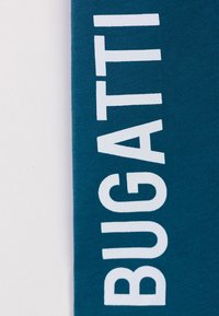 Tessuto in cotone teal con audace scritta bianca che dice "BUGATTI" in un moderno carattere sans-serif, con una finitura liscia e leggermente texture.