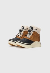 Une paire de bottes d'hiver marron et noires avec une doublure en polaire crème et des lacets noir et blanc sur fond blanc.