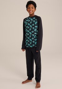Párové pyžamo s dlhým rukávom, ktoré obsahuje čierny top s tyrkysovým geometrickým vzorom a zodpovedajúce čierne nohavice. Mäkkučký materiál, voľný strih, elastické manžety.