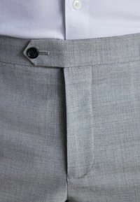 Helle graue, taillierte Hose aus strukturiertem Stoff, mit einem einzigen Knopfverschluss und scharfen Falten vorne.