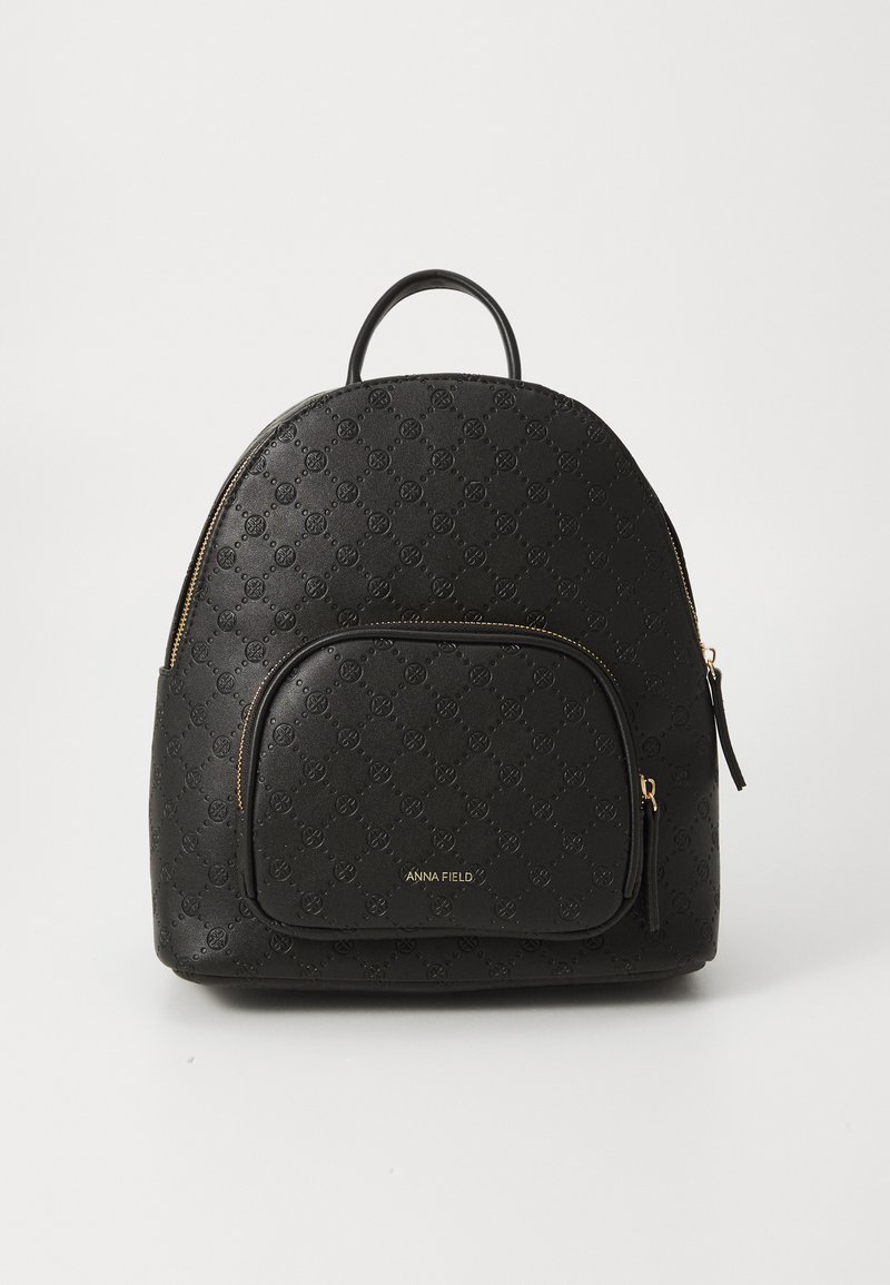 Sac à dos en cuir synthétique noir avec un motif de logo embossé, de forme arrondie, fermeture éclair dorée et une poche avant avec fermeture éclair.