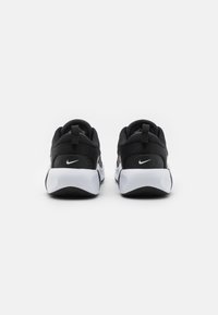 Czarne buty sportowe z siateczkowym wykończeniem, białymi akcentami i płaską gumową podeszwą. Posiadają logo na pięcie oraz uchwyt z tyłu.