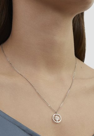 Silberne Halskette mit einem runden Anhänger, der ein Baumdesign zeigt. Die Kette ist dünn mit kleinen Gliedern und wird um den Hals getragen.