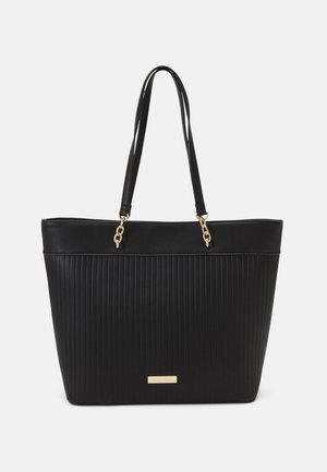 Borsa a mano nera realizzata in materiale sintetico a coste con dettagli in catena d'oro. Caratterizzata da una parte superiore piatta e da lunghe cinghie per la spalla, per un facile trasporto.