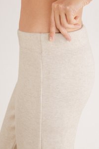 Beige legging heeft een gladde, rekbare textuur en een brede elastische tailleband met een subtiel gemêleerd patroon en geen zichtbare naden.