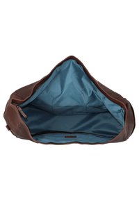 Intérieur d'un sac en cuir marron avec un doublure bleue. Comprend une fermeture à glissière et une poche de rangement avec un élastique. Texture lisse.