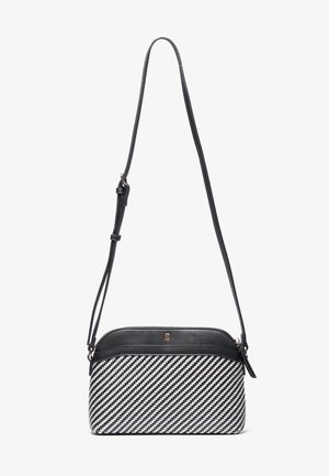 Bolso bandolera tejido en blanco y negro con correa ajustable de cuero negro y cierre con cremallera en la parte superior.