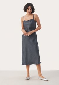 Rochie fără mâneci din satin gri închis, cu decolteu drept, siluetă fluidă și textură subtilă. Purtați cu pantofi plate argintii.