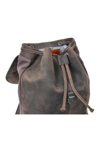 Bolso de cuero marrón con cordón ajustable, acabado texturizado, que cuenta con un cierre metálico, detalles cosidos y un panel de tela en contraste.