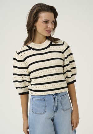 Knit sweater in cream with black stripes, featuring short puffed sleeves and openwork details. Paired with light blue high-waisted jeans.