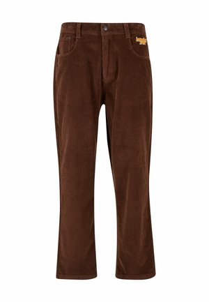 Pantalones de pana marrones con canalones verticales, que cuentan con un cierre de botón, cinco bolsillos y un acento de logo naranja en el bolsillo delantero.