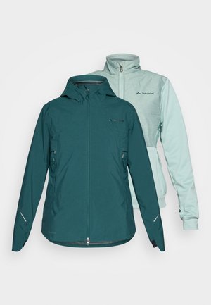 Due giacche in esposizione: una giacca impermeabile color teal con zip e cappuccio, e una giacca in fleece verde menta con colletto alzato e chiusura a zip.